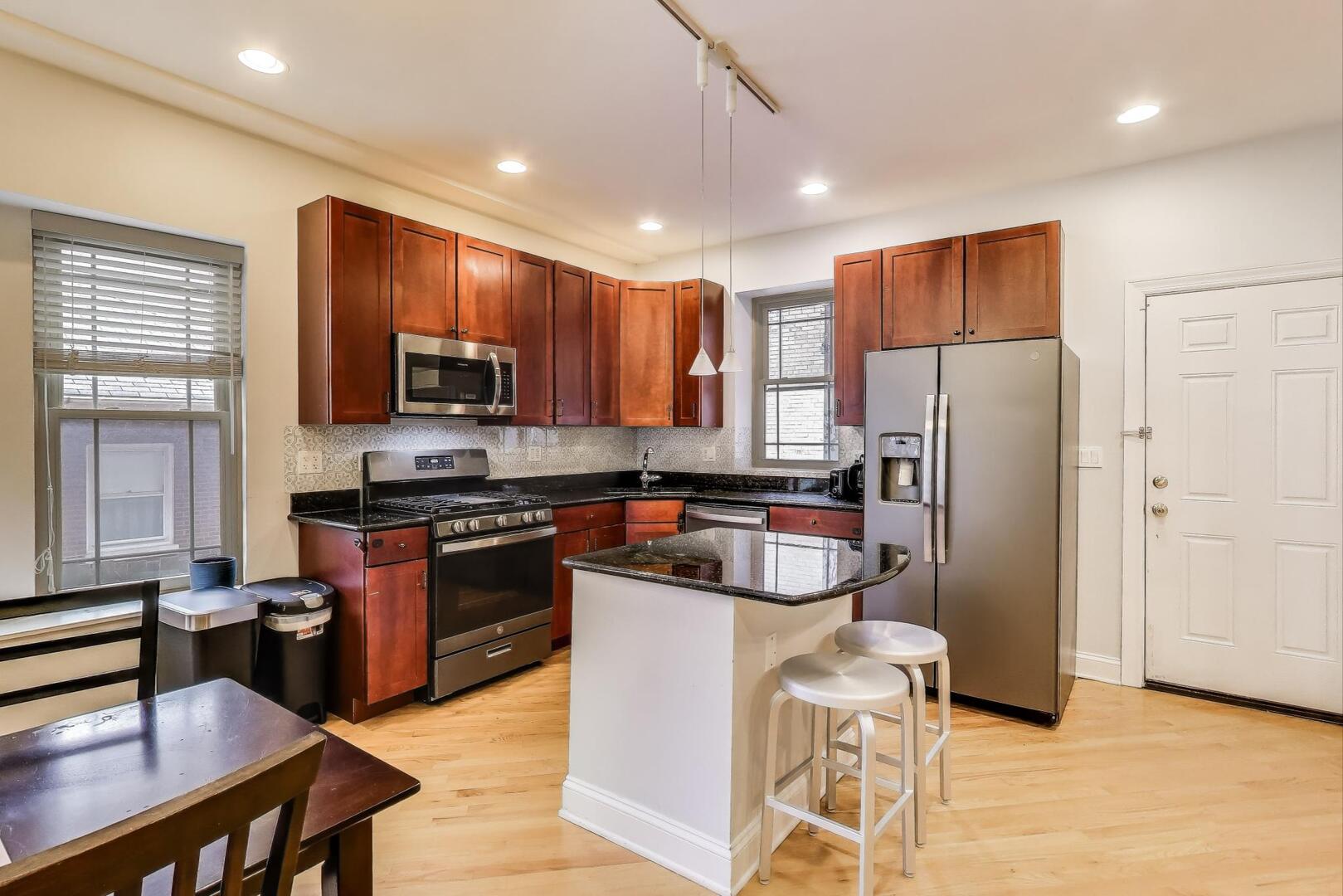 911 Maple Avenue, Unit 1N Evanston, IL 60202 - Photo 12 of 29 a kitchen with stainless steel appliances granite countertop a refrigerator a stove top oven a sink dishwasher and white cabinets with wooden floor