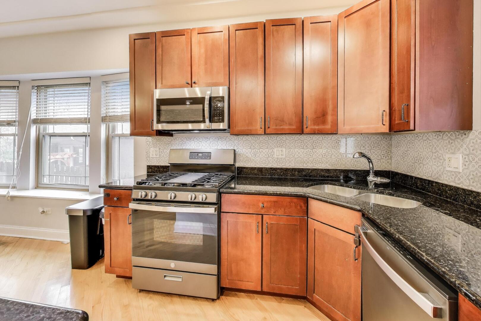 911 Maple Avenue, Unit 1N Evanston, IL 60202 - Photo 14 of 29 a kitchen with stainless steel appliances granite countertop a stove a sink and a microwave