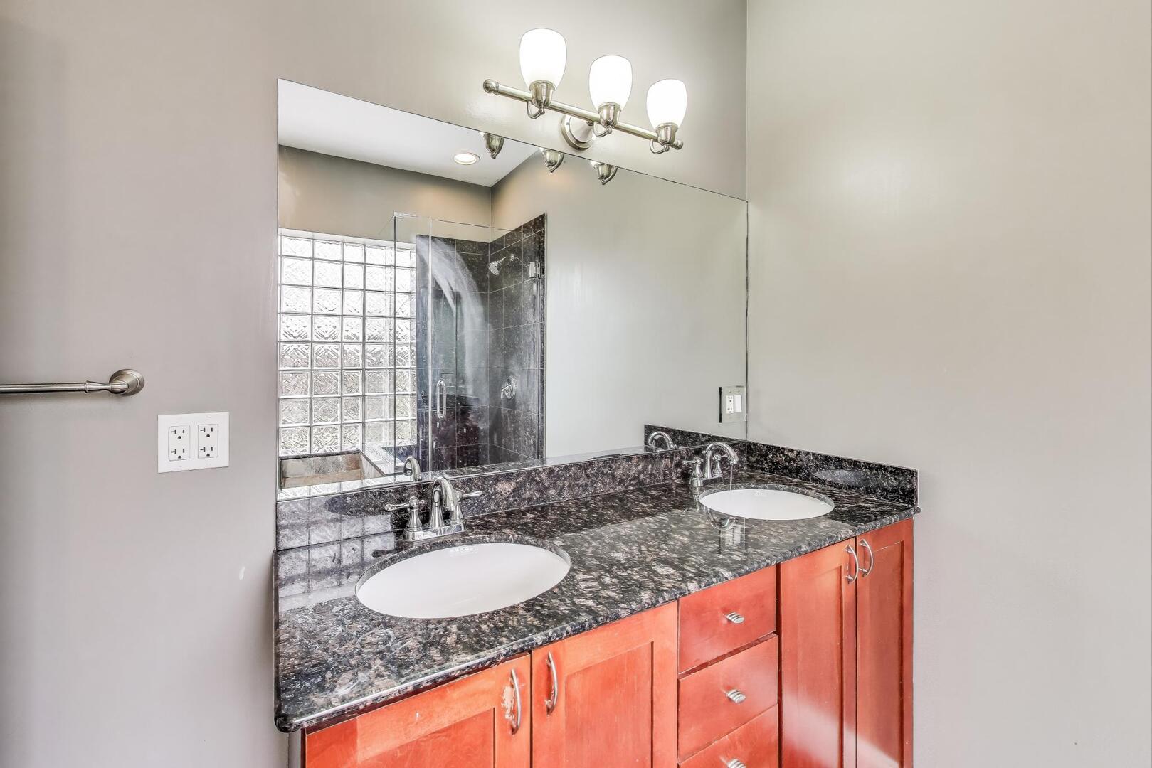 911 Maple Avenue, Unit 1N Evanston, IL 60202 - Photo 20 of 29 a bathroom with a granite countertop sink a mirror and a window