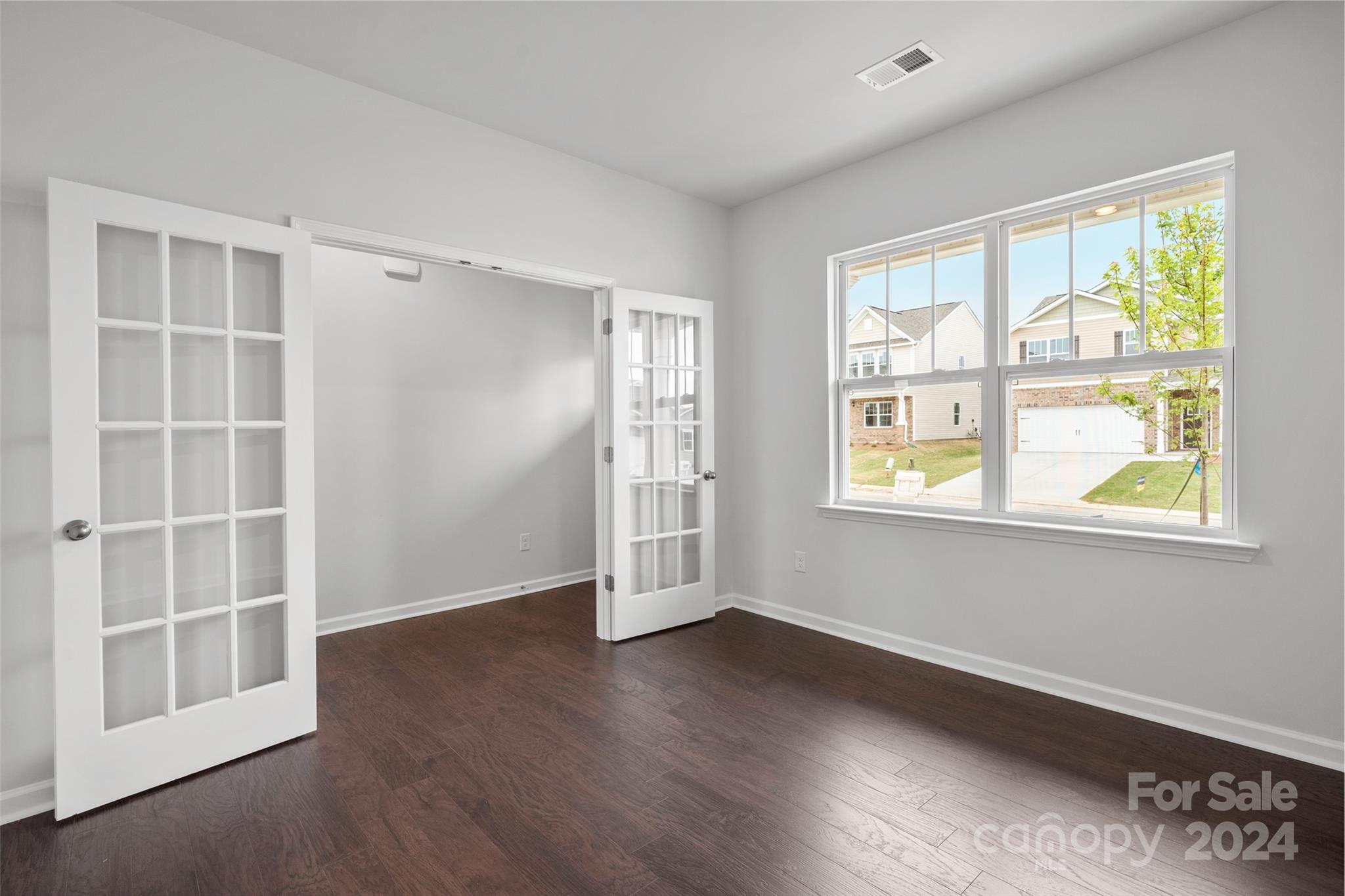 83 Callie River Clyde, NC 28721 - Photo 14 of 26 an empty room with wooden floor and windows