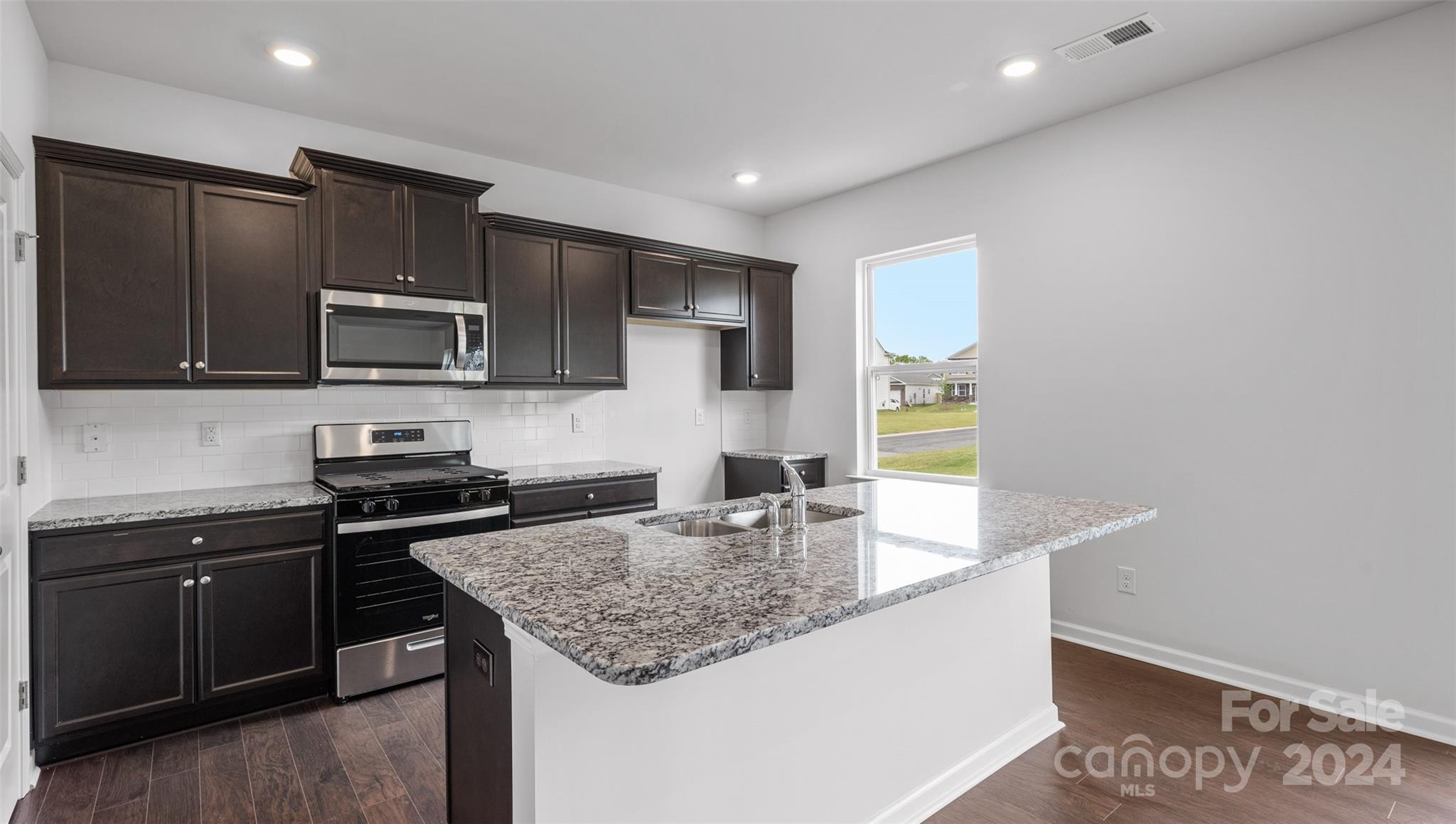 83 Callie River Clyde, NC 28721 - Photo 16 of 26 a kitchen with granite countertop stainless steel appliances stove microwave refrigerator and sink