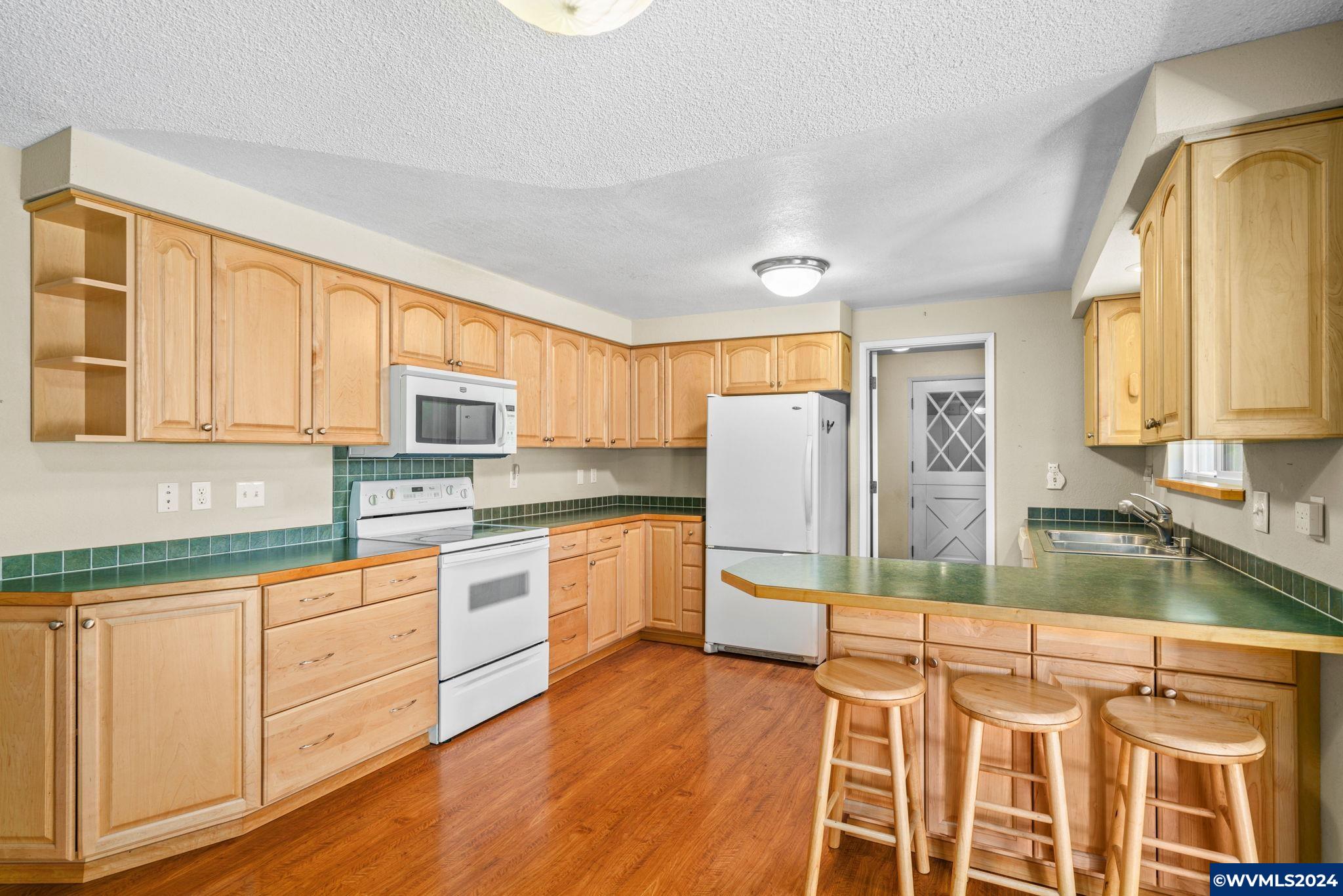 2254 8th Street Springfield, OR 97477 - Photo 8 of 34 a kitchen with stainless steel appliances granite countertop a stove a sink and a refrigerator