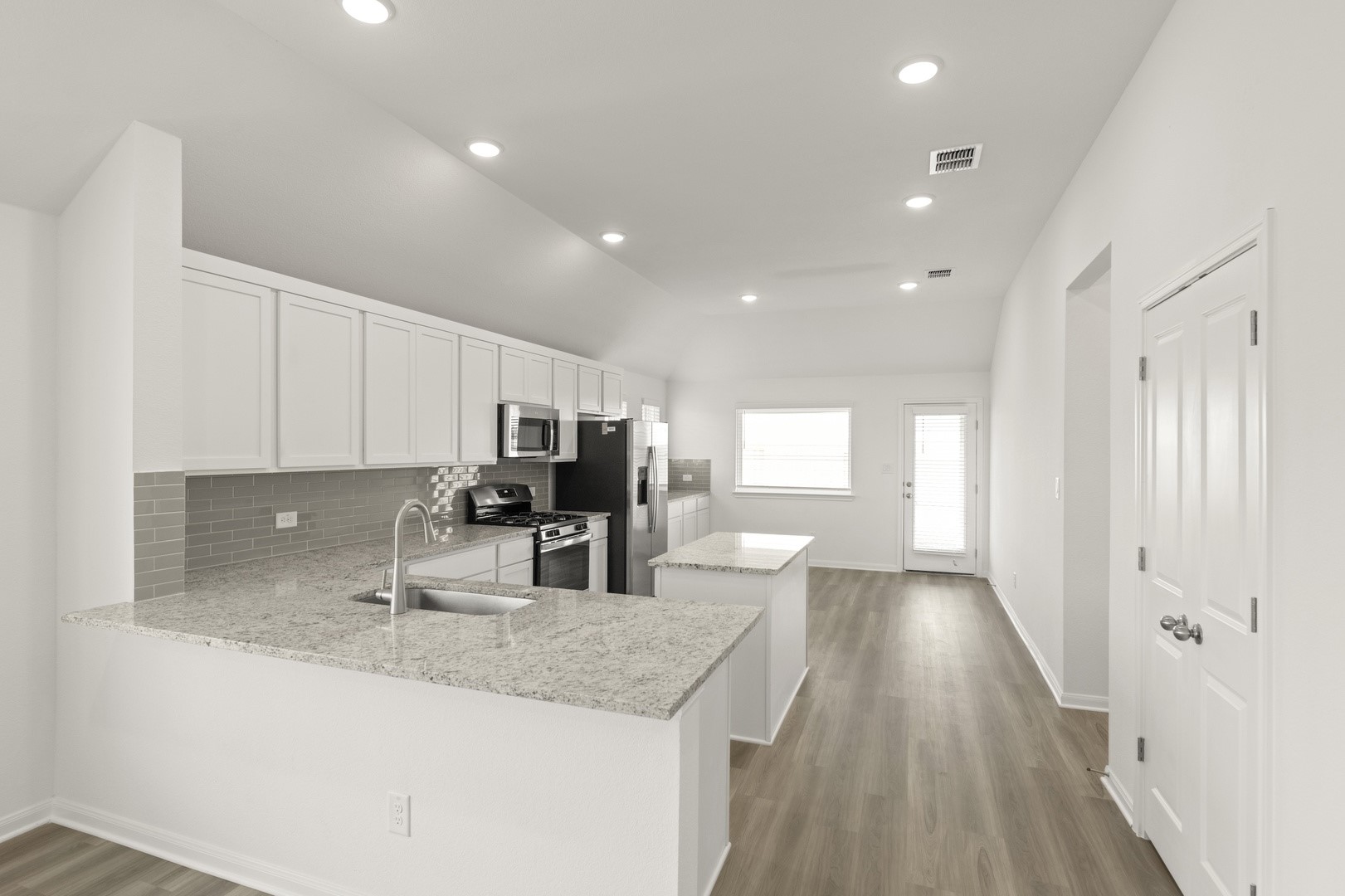 3729 Pin Oak Hills Seguin, TX 78155 - Photo 8 of 22 Kitchen with a center island, white cabinets, backsplash, appliances with stainless steel finishes, and lofted ceiling