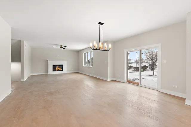 a view of a livingroom with a chandelier a fireplace and a chandelier
