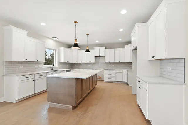 a large kitchen with granite countertop a sink counter space stainless steel appliances and cabinets