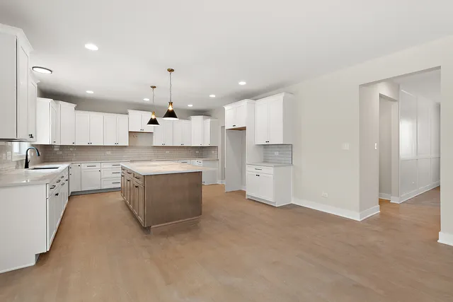 a large kitchen with kitchen island a sink stainless steel appliances and cabinets
