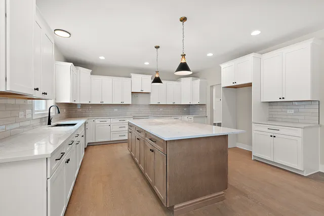 a large kitchen with stainless steel appliances granite countertop a sink stove and refrigerator