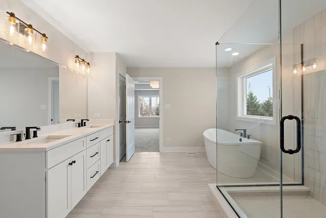 a bathroom with a double vanity sink a mirror and a bathtub