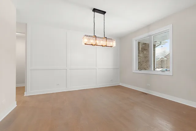 an empty room with windows and chandelier