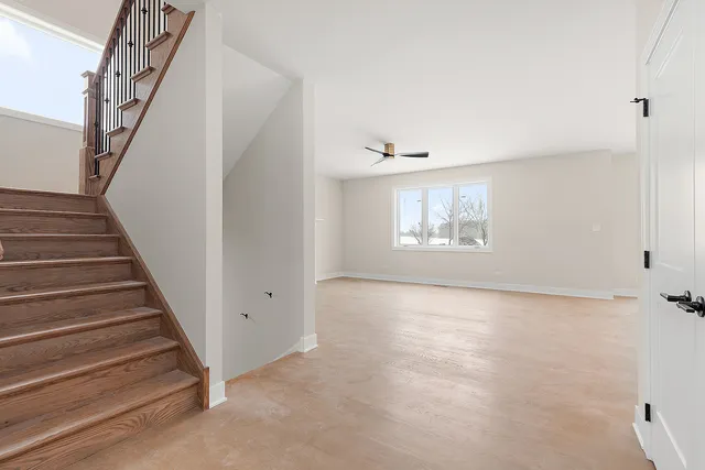 a view of an empty room with stairs and a window