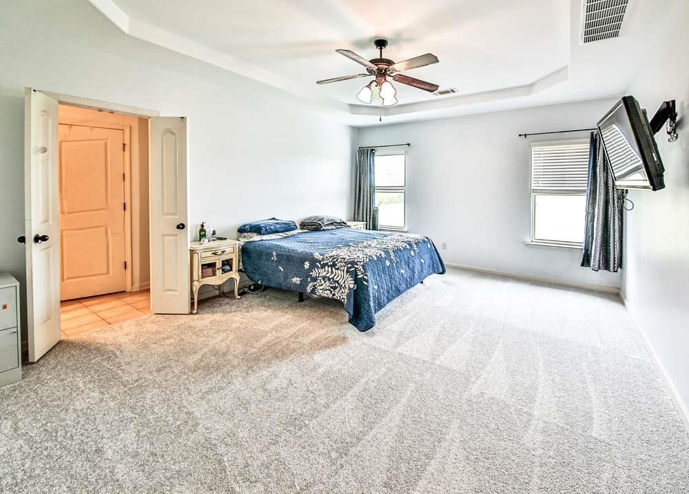 82 Ridgetop Cove Atoka, TN 38004 - Photo 15 of 31 Bedroom featuring a raised ceiling, light carpet, and a ceiling fan