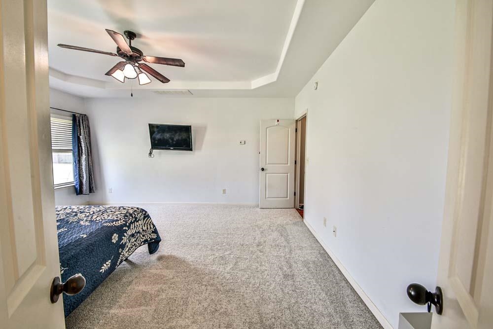 82 Ridgetop Cove Atoka, TN 38004 - Photo 16 of 31 Carpeted bedroom with a tray ceiling and a ceiling fan