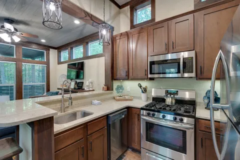 a kitchen with stainless steel appliances granite countertop a sink stove and microwave