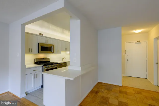 a kitchen with stainless steel appliances a stove microwave and sink