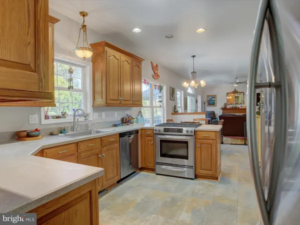 a kitchen with granite countertop a sink window and cabinets