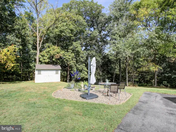 a aerial view of a house next to a big yard and large trees