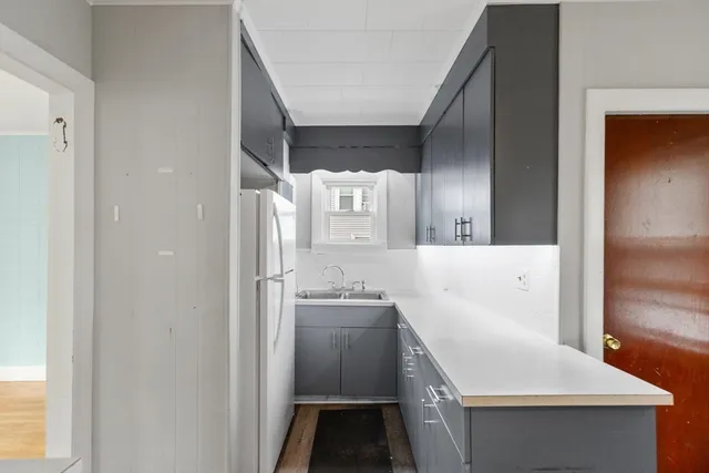 a kitchen with a sink a refrigerator and cabinets