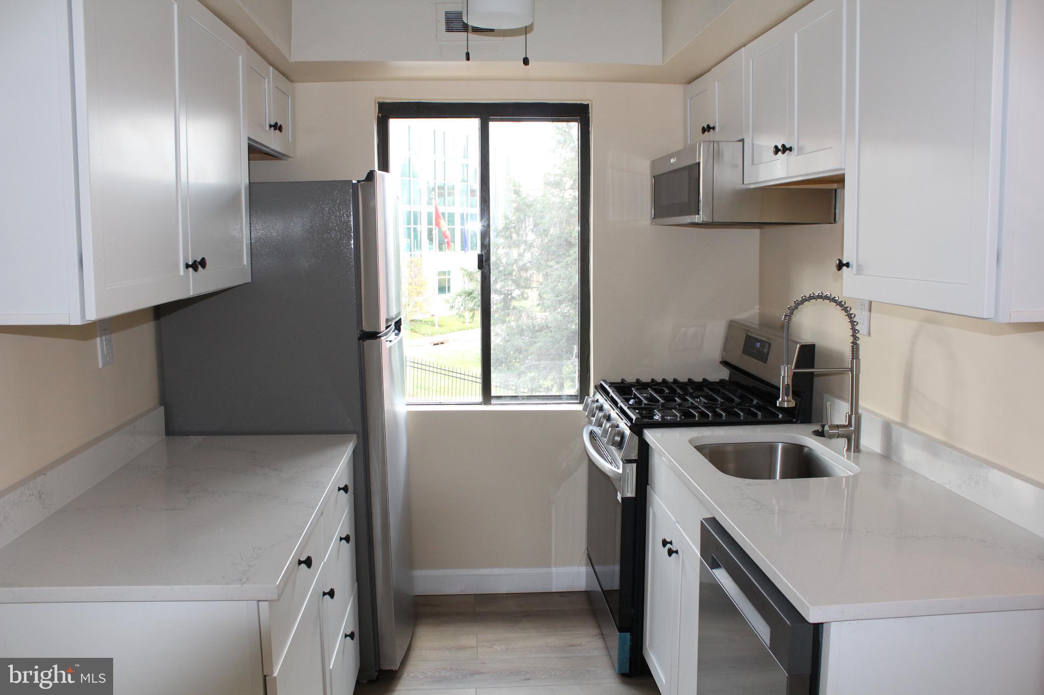 a kitchen that has a sink a stove and a refrigerator