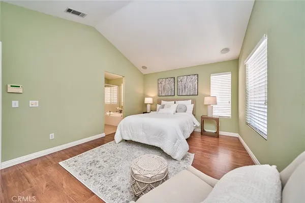 a bedroom with a bed and wooden floor