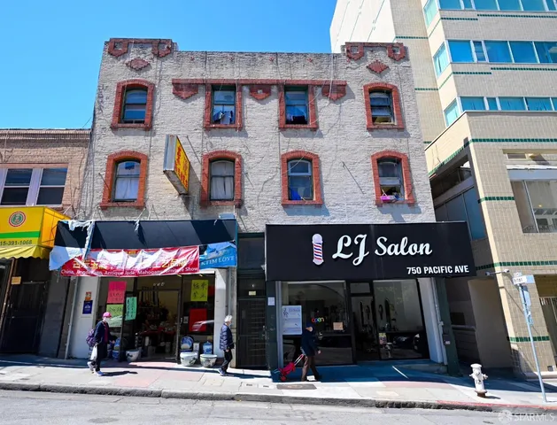 a front view of multi story building with retail shops