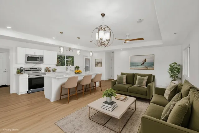 a living room with furniture couches and kitchen view