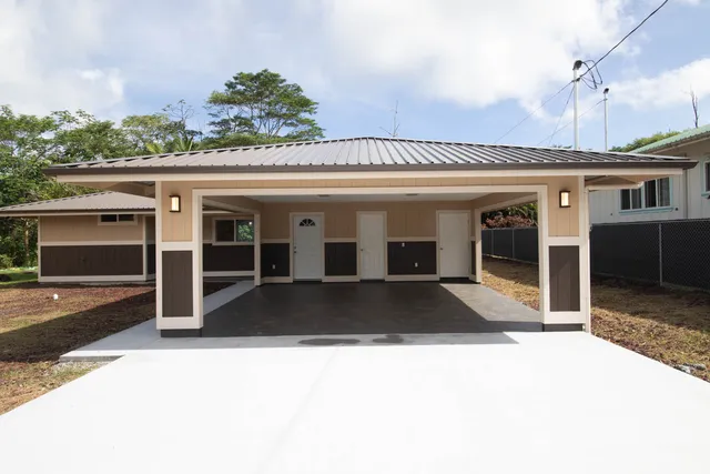 a view of a house with backyard and parking