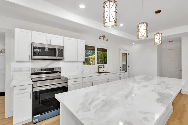 a kitchen with stainless steel appliances a stove sink microwave and refrigerator