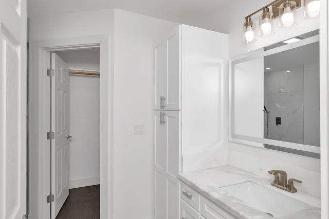 a bathroom with a granite countertop sink and a mirror