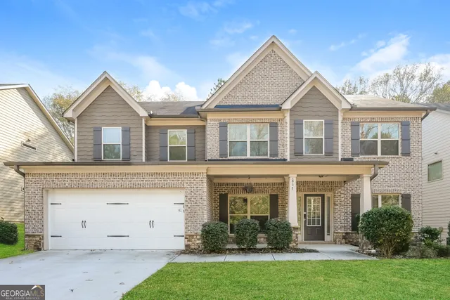 a front view of a house with a yard and plants
