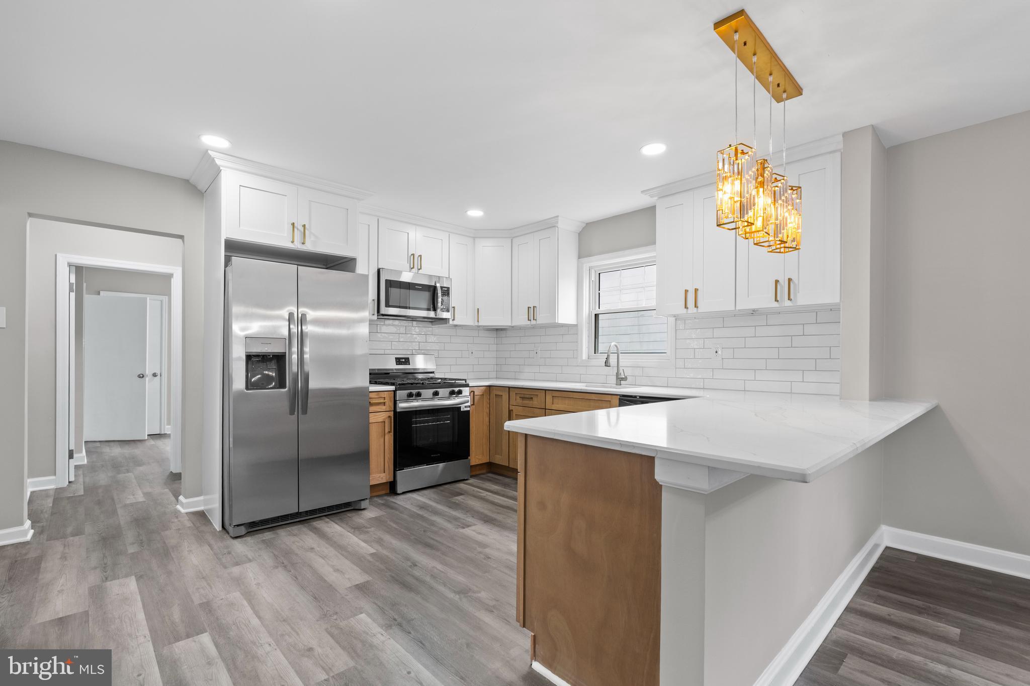 131 Lippincott Avenue Riverside, NJ 08075 - Photo 10 of 34 a kitchen with stainless steel appliances granite countertop a sink a stove a refrigerator and island with wooden floor