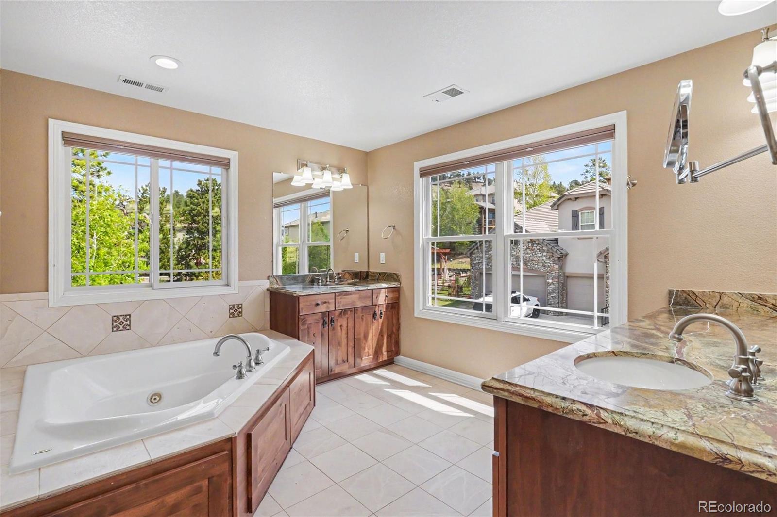 791 Elk Rest Road Evergreen, CO 80439 - Photo 22 of 46 a bathroom with a granite countertop tub sink and large window