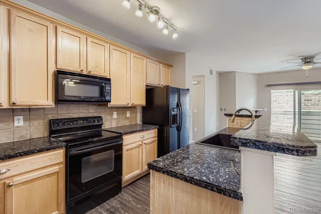 a kitchen with stainless steel appliances granite countertop a stove microwave and sink