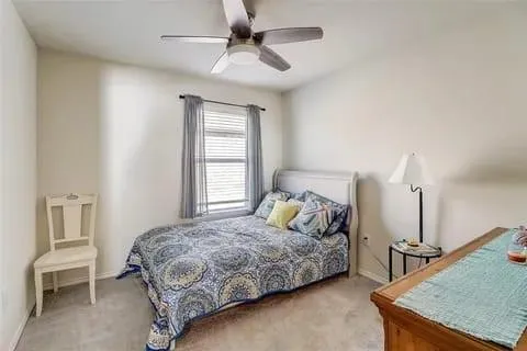 a bedroom with a bed a chandelier and a window