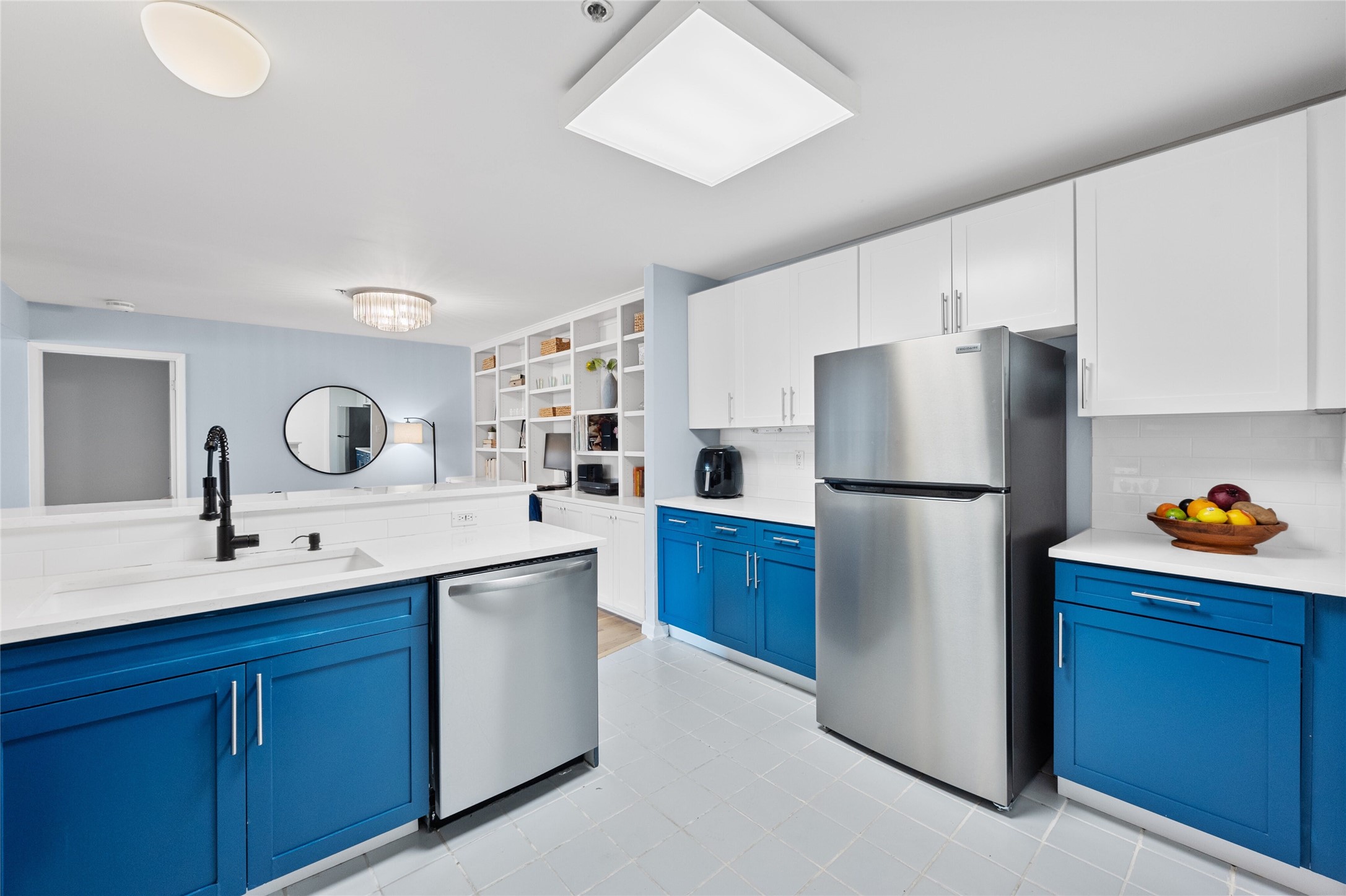 40 North Interstate Highway 35, Unit 2B2 Austin, TX 78701 - Photo 4 of 14 A bright, bespoke kitchen, defined by its white countertop, which provides a clean and modern look. Adding a pop of color, the cabinets are a striking shade of blue, adding a touch of vibrancy to the overall kitchen design.