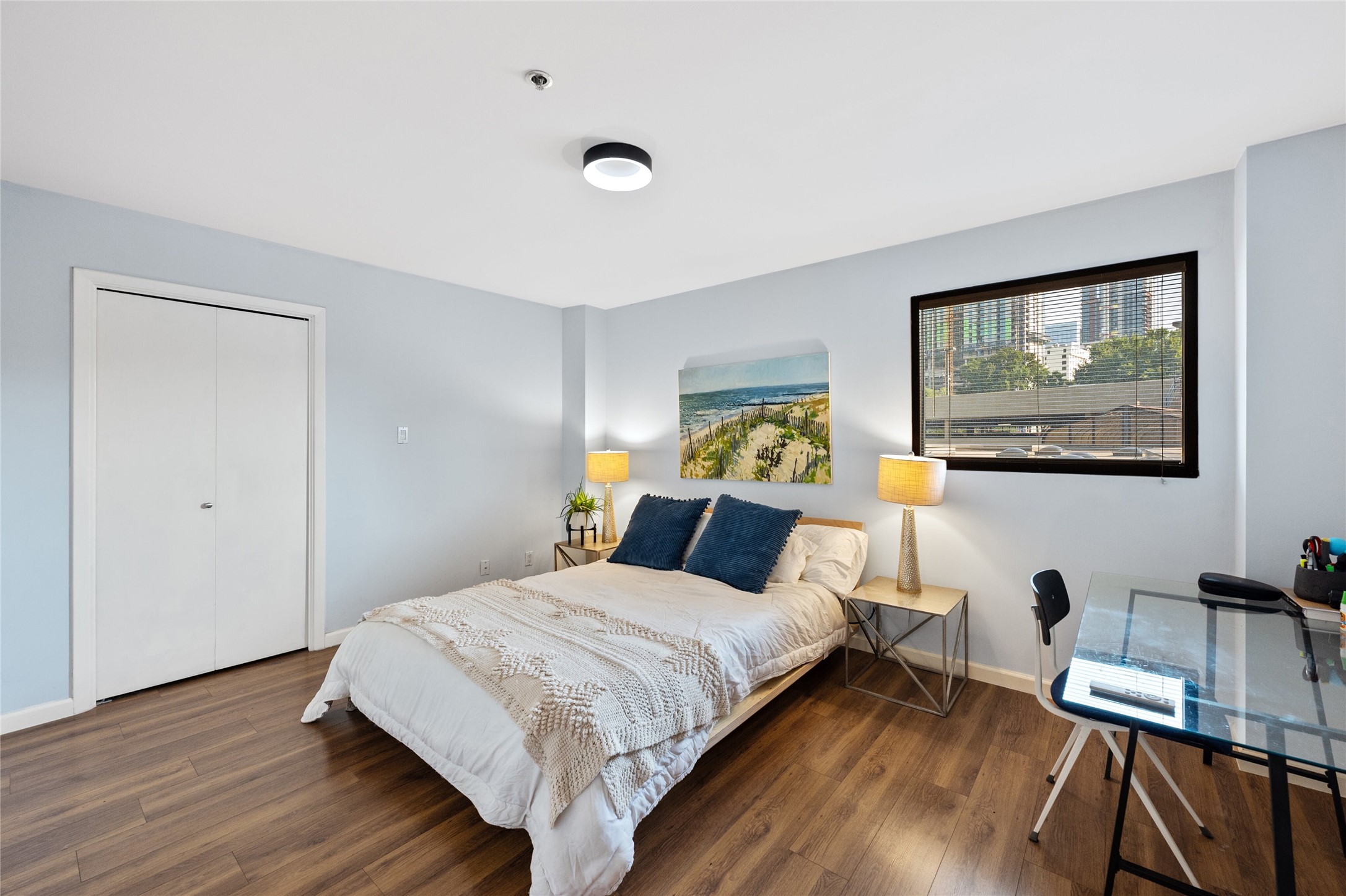 40 North Interstate Highway 35, Unit 2B2 Austin, TX 78701 - Photo 7 of 14 The second bedroom is notable for its generous space and thoughtful design elements. A window invites natural light into the room, brightening up the interior and creating a pleasant atmosphere. Adding to its appeal, the bedroom features pocket doors that maximize space utilization and contribute to the room's open and uncluttered feel.