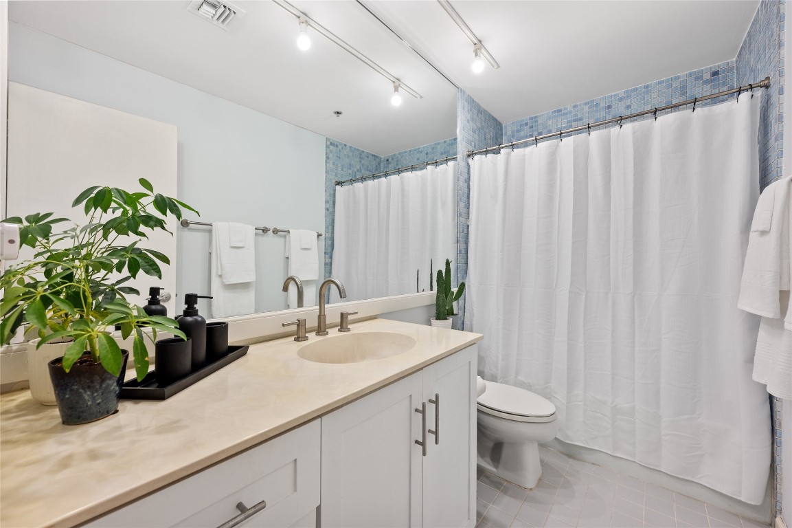 40 North Interstate Highway 35, Unit 2B2 Austin, TX 78701 - Photo 8 of 14 The second bathroom offers a combination of functionality and aesthetics. A sizable mirror adorns the space, enhancing its brightness and visual appeal.
