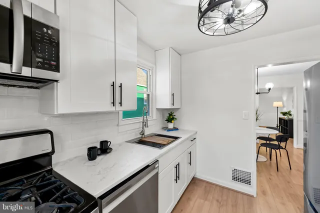 a kitchen with a sink cabinets and wooden floor
