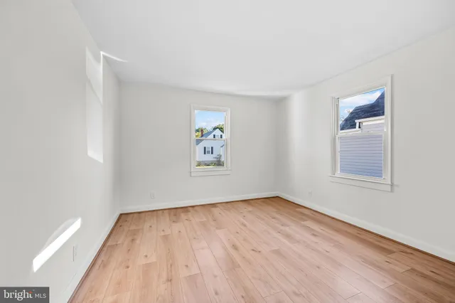 an empty room with a hardwood and ceiling fan