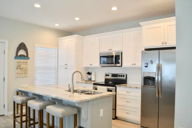a kitchen with stainless steel appliances granite countertop a stove a sink and a refrigerator