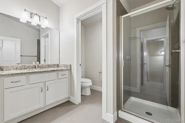 a bathroom with a granite countertop sink toilet and shower
