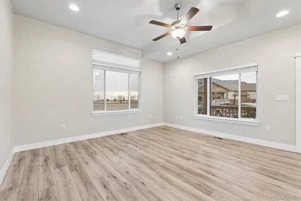 a view of an empty room with a window and wooden floor