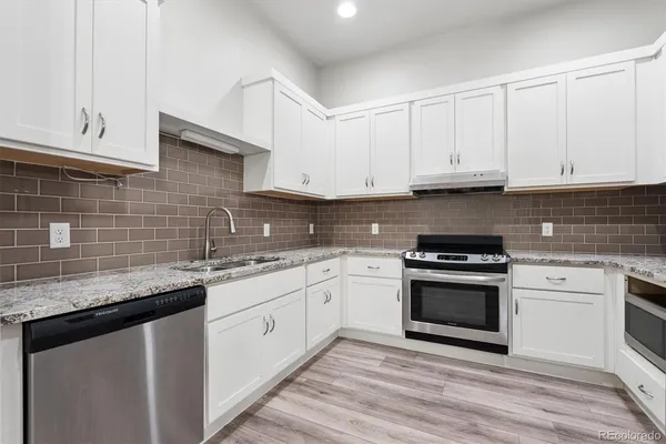 a kitchen with stainless steel appliances granite countertop a sink stove and cabinets