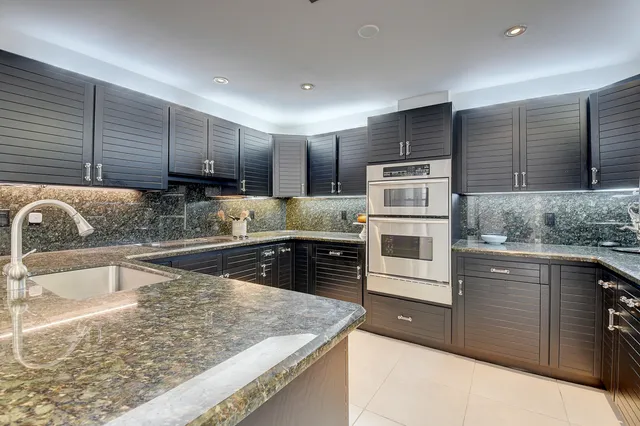 a kitchen with stainless steel appliances granite countertop a sink and wooden cabinets