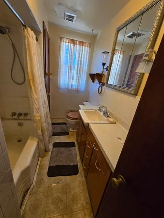 a bathroom with a granite countertop sink a toilet and shower