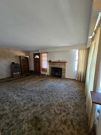 an empty room with furniture and a fireplace