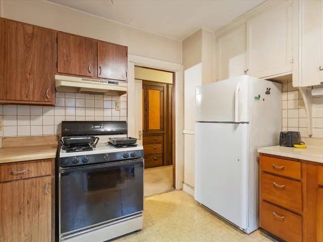 a kitchen with refrigerator a stove a sink and cabinets