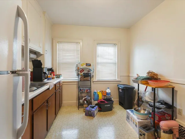 a kitchen with refrigerator and cabinets