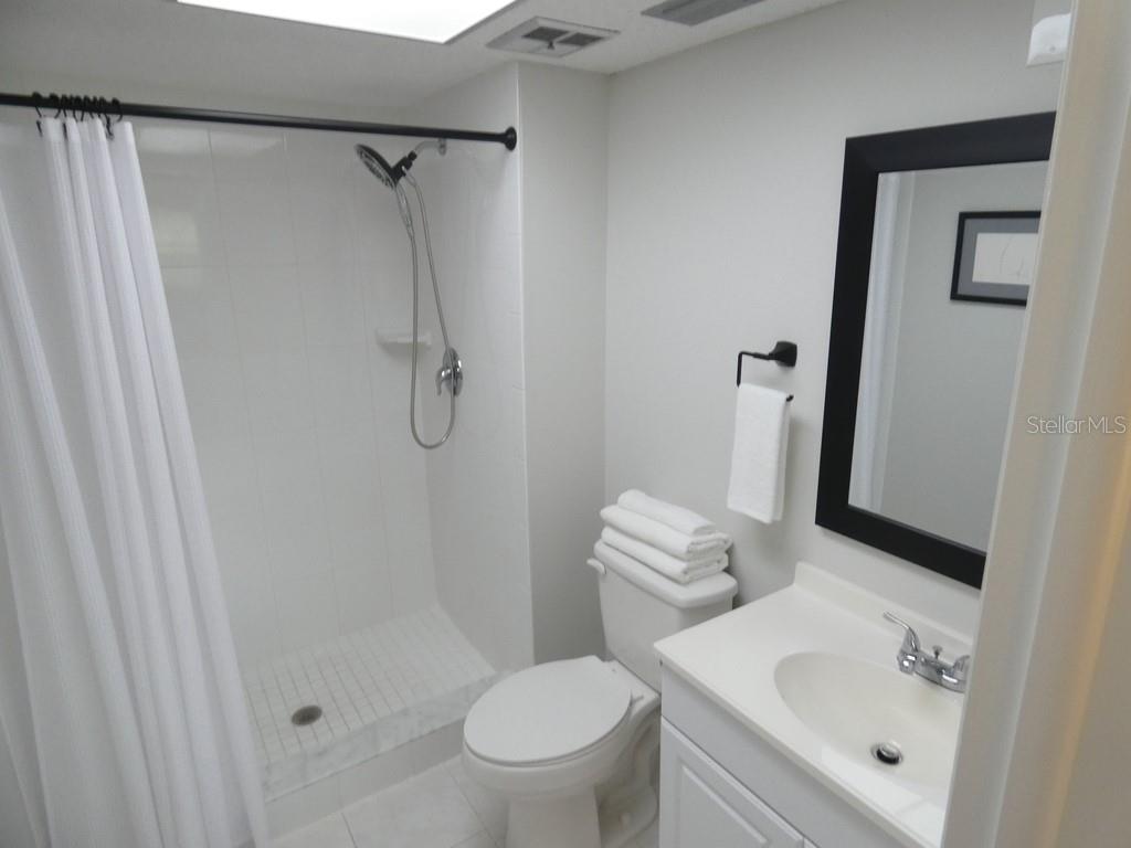 1701 Pinehurst Road, Unit 9G Dunedin, FL 34698 - Photo 6 of 22 a bathroom with a toilet sink vanity and shower