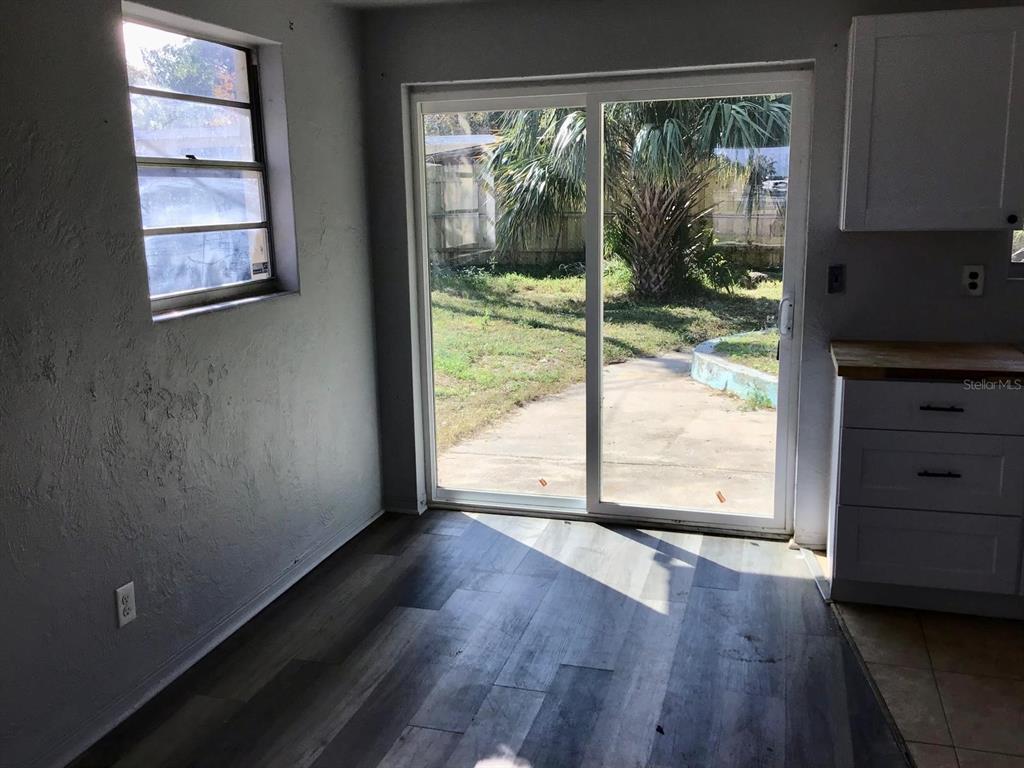 854 Derbyshire Road Daytona Beach, FL 32117 - Photo 4 of 12 an empty room with wooden floor and windows