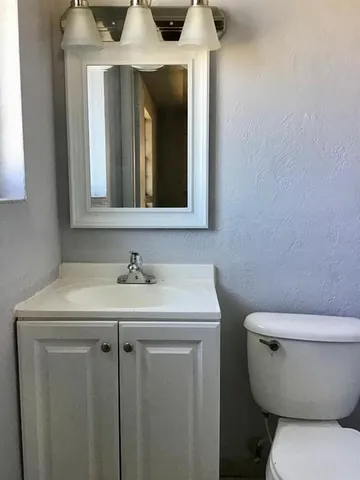 a bathroom with a toilet sink and mirror